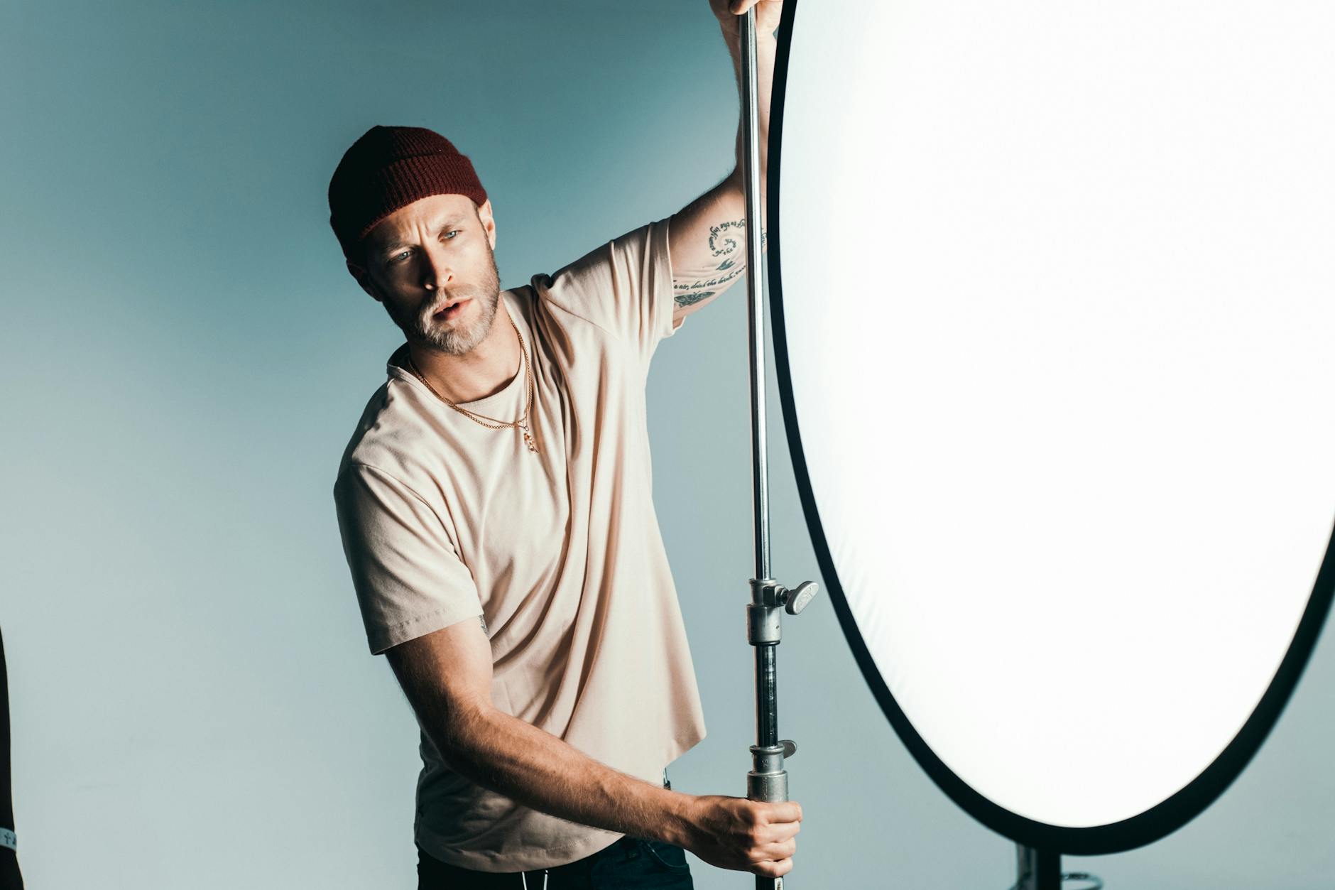 工作室中摄影师调整三光源照明 (photographer adjusting three lights studio)